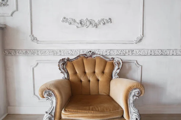 Sala de estar con sillón beige con estilo antiguo en el diseño de pared blanca de lujo bas-relieve molduras de estuco elementos roccoco —  Fotos de Stock