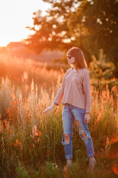 Unga moderna girl på bakgrunden sunset. — Stockfoto