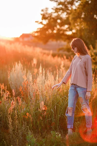 Jovem menina moderna no fundo por do sol . — Fotografia de Stock