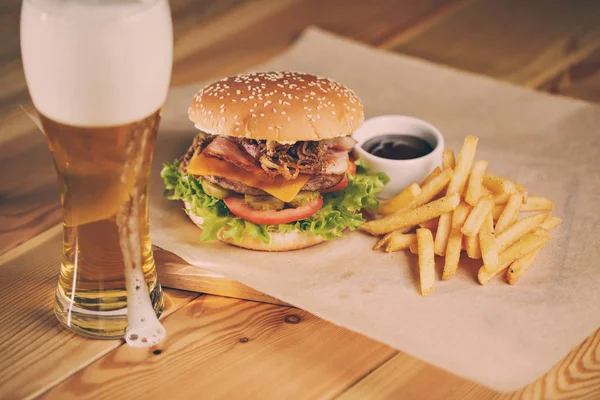 Fish and Chips Burger s smažené bramborové slámy, čerstvý salát vychlazené pivo — Stock fotografie