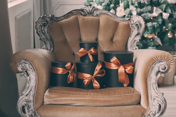 Csomagolva fekete díszdobozok, szalagok, mint karácsony bemutat egy székre — Stock Fotó