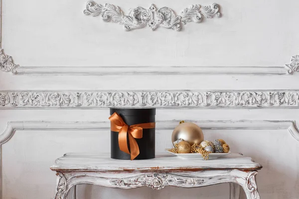 Τυλιγμένο δώρο μαύρα κουτιά με κορδέλες, όπως δώρα Χριστουγέννων σε ένα πίνακα πολυτελή λευκό τοίχο ανάγλυφο στόκων καλούπια roccoco στοιχεία σχεδιασμού — Φωτογραφία Αρχείου