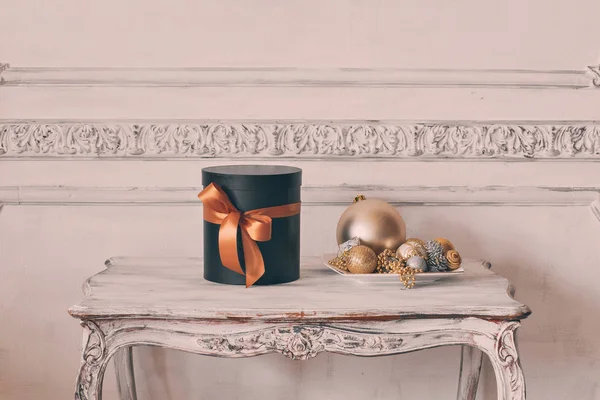 Τυλιγμένο δώρο μαύρα κουτιά με κορδέλες, όπως δώρα Χριστουγέννων σε ένα πίνακα πολυτελή λευκό τοίχο ανάγλυφο στόκων καλούπια roccoco στοιχεία σχεδιασμού — Φωτογραφία Αρχείου