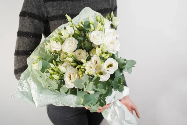 Rich bouquet with eustoma lisianthus in woman hand . flowers and eucalyptus mint packaging — Stock Photo, Image