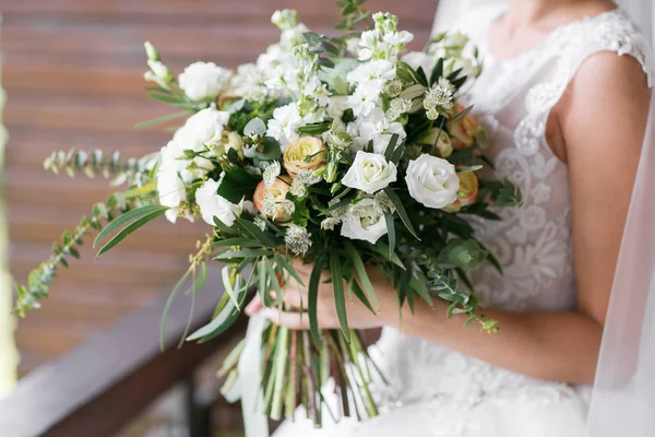 Букет невесты. Невесты. Белые цветы и зелень, украшенные шелковой лентой, лежат на винтажном деревянном стуле — стоковое фото