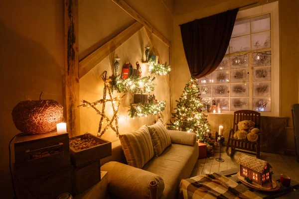 Imagen tranquila del interior de la casa moderna sala de estar decorado árbol de Navidad y regalos, sofá, mesa cubierta con manta . — Foto de Stock