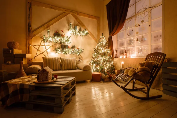 Imagen tranquila del interior de la casa moderna sala de estar decorado árbol de Navidad y regalos, sofá, mesa cubierta con manta . —  Fotos de Stock