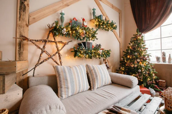 Imagen tranquila del interior de la casa moderna sala de estar decorado árbol de Navidad y regalos, sofá, mesa cubierta con manta . —  Fotos de Stock