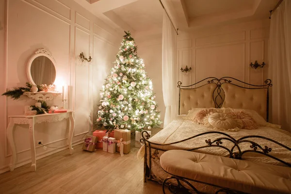 Imagen tranquila del interior Árbol de Año Nuevo clásico decorado en una habitación con cama — Foto de Stock