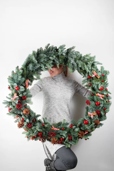 Jovem segurando Natal grinalda grande em mãos em luz, feriados sazonais, tema rústico, adornando — Fotografia de Stock