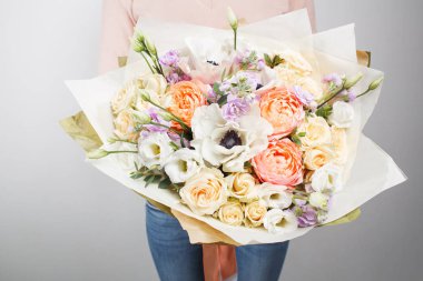 Çiçekçi iş başında. Zengin buket farklı renk ve çiçek olun. Ellerinde bir grup