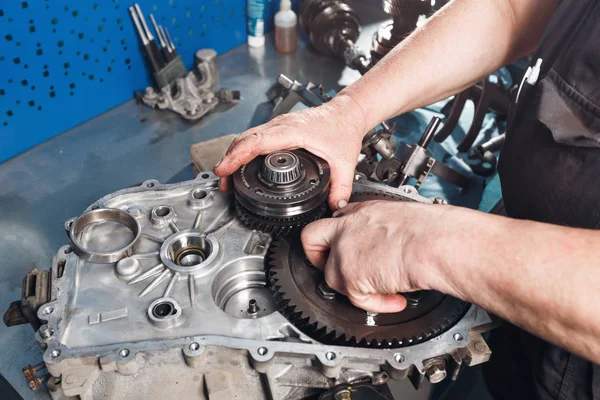 Tvärsnitt av en bil växellåda. mekanikerna jobbar i garaget. hand mekaniker i arbetskläder — Stockfoto