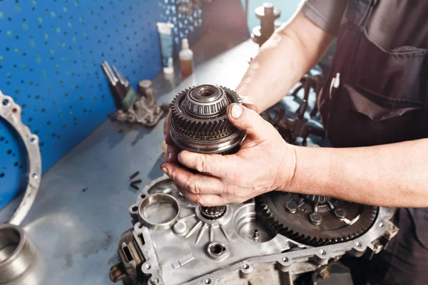 Tvärsnitt av en bil växellåda. mekanikerna jobbar i garaget. hand mekaniker i arbetskläder — Stockfoto