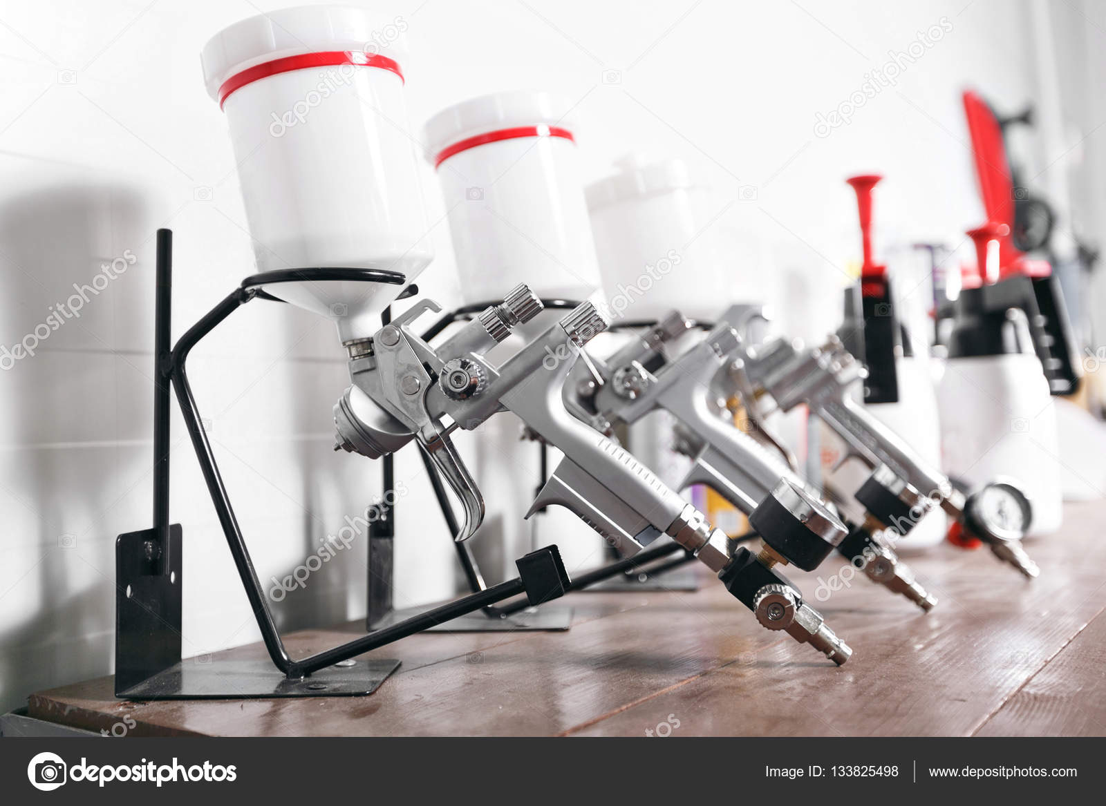 Spray gun on wood table. in auto service. used for industrial painting