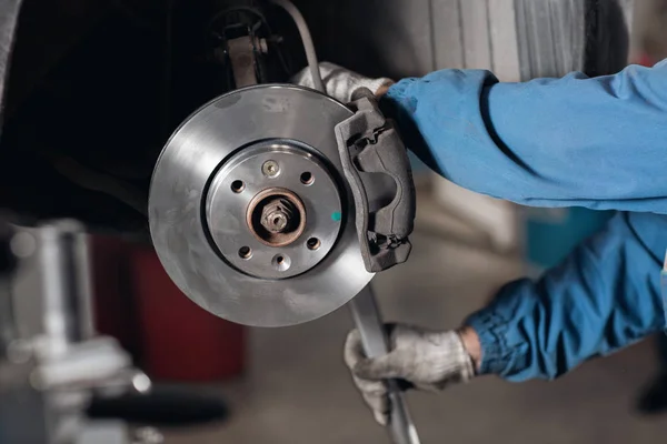 Mudar a unidade antiga para o novo disco de freio no carro em uma garagem. Auto reparação mecânica  . — Fotografia de Stock