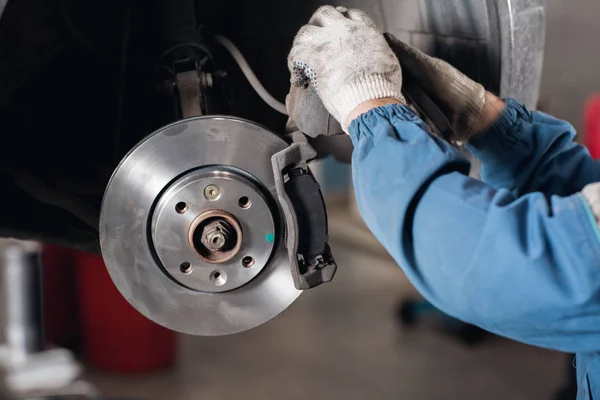 Cambiar la unidad de edad a la Marca nuevo disco de freno en el coche en un garaje. Auto mecánico de reparación  . —  Fotos de Stock