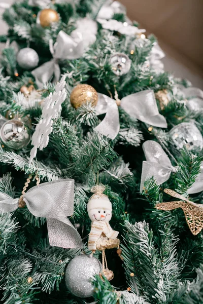 Gros plan de l'arbre de Noël avec des ornements boules, arc, flocons de neige, cônes de pin et lumières . — Photo