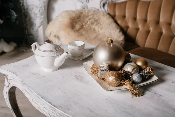 枝スプルースと花輪で飾られた暖炉の背景とテーブルの上のクリスマスの装飾. — ストック写真