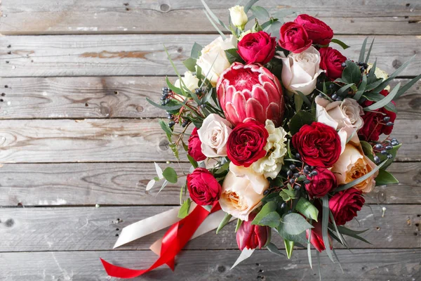 Bouquet of red roses and Other colors flowers on wooden background, copy space. top view — Stock Photo, Image