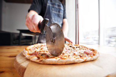 Şef baker Tekdüzen mavi önlük kesme Pizza'da mutfak içinde closeup el