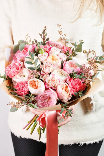 Colección de diferentes variedades de rosas de jardín, claveles y eucaliptos. Las manos de las niñas sosteniendo colores suaves ramo de flores sobre fondo blanco . — Foto de Stock