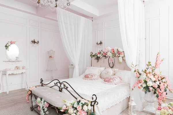 wrought iron bed in the gentle light room. spring flower decoration.