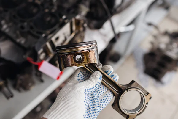Mécanicien automobile en garage avec vieux piston moteur de voiture . — Photo