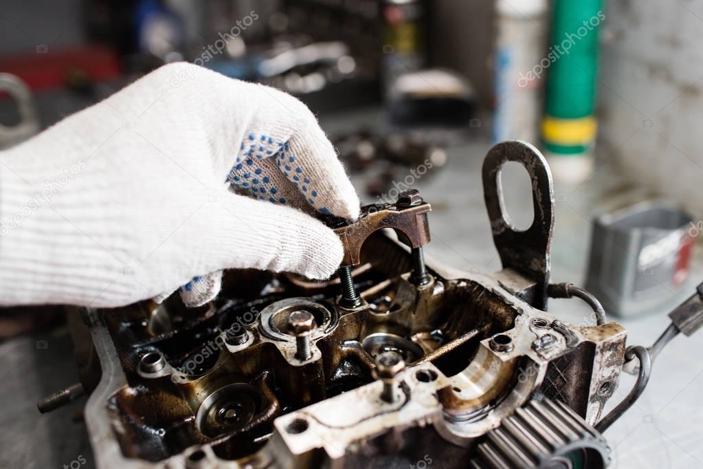 Engine crankshaft, valve cover, pistons. mechanic repairman at automobile car engine maintenance repair work