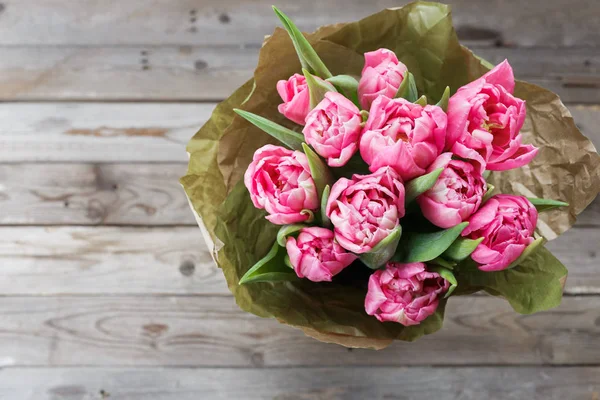 Strauß rosa Tulpen auf einem hölzernen Hintergrund. Frühlingsblumen. Hintergrund Muttertag. — Stockfoto