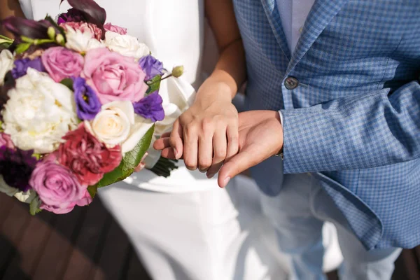 Чоловік наречений тримає дівчат за руку. Барвистий весільний букет. день весілля, аксесуари для нареченої — стокове фото