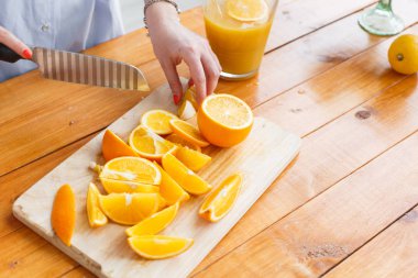 Anne oğluna meyve keser. dilimlenmiş portakal ahşap kesme tahtası üzerinde. Sağlıklı ve lezzetli kahvaltı