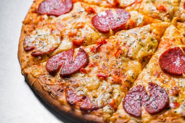 Biberli pizza, yakın çekim. metal masa üzerinde adet kesim tarafından. Dolgu tarih seçici odak