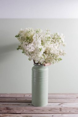 Lila beyaz leylak çiçekler vazoda. Ahşap masa üzerinde rustik Can beyaz çiçeklerle bahar arka plan.