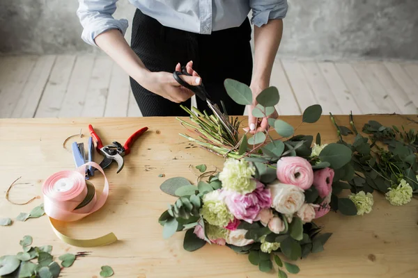 Florista en el trabajo: bonita mujer joven haciendo ramo moderno de moda de diferentes flores — Foto de Stock