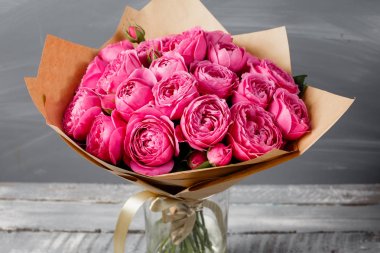 Şakayık Misty kabarcıklar yükseldi. Koyu gri rustik ahşap arka plan üzerinde cam vazoda pembe gül buketi çiçek. Eski püskü şık ev dekorasyonu.