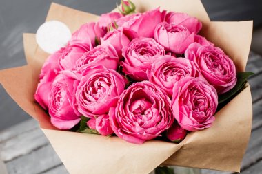 Şakayık Misty kabarcıklar yükseldi. Koyu gri rustik ahşap arka plan üzerinde cam vazoda pembe gül buketi çiçek. Eski püskü şık ev dekorasyonu.