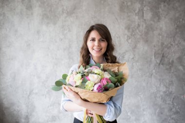 İş yerinde çiçekçi: genç ve güzel kadın moda modern buket farklı çiçek yapma