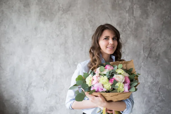 Florista no trabalho: mulher muito jovem fazendo moda buquê moderno de flores diferentes — Fotografia de Stock