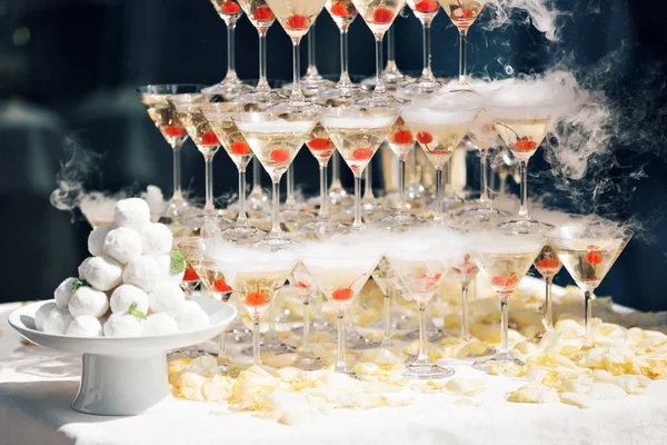 Pirámide de champán en evento, fiesta o banquete. cereza en el vaso. Flotadores de hielo seco —  Fotos de Stock