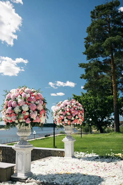 Hermosos elementos de decoración de diseño de ceremonia de boda con flores frescas composición, diseño floral, pétalos rosas y sillas . — Foto de Stock