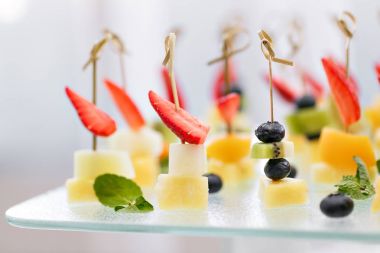 Appetizers, gourmet food - canape with cheese and strawberries, blue-berries catering service. selective focus, top view. clipart