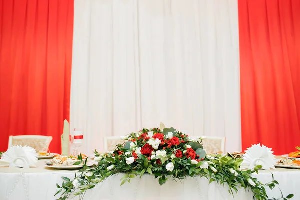 新婚夫婦のテーブルに赤と白のバラの結婚式の花. — ストック写真