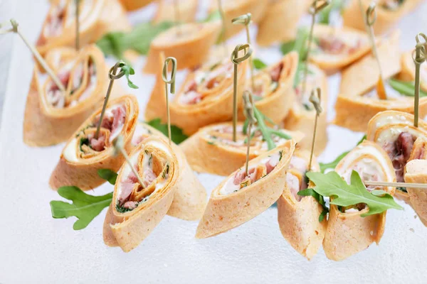 stock image Assorted canape with cheese, meat, rolls, tortilla and fruit salad. Food to accompany the drinks. the buffet at the Banquet. A reason to celebrate the event. Wedding or anniversary