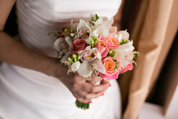Невеста держит свадебный букет близко. розовые и белые розы, фрезия, брюния украшены в композиции — стоковое фото