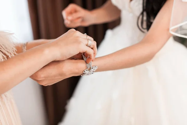 Подружка невесты одевает невесту в день свадьбы. Подружка невесты помогает с белым платьем перед церемонией. Роскошное свадебное платье. Лучшее брачное утро. концепция — стоковое фото