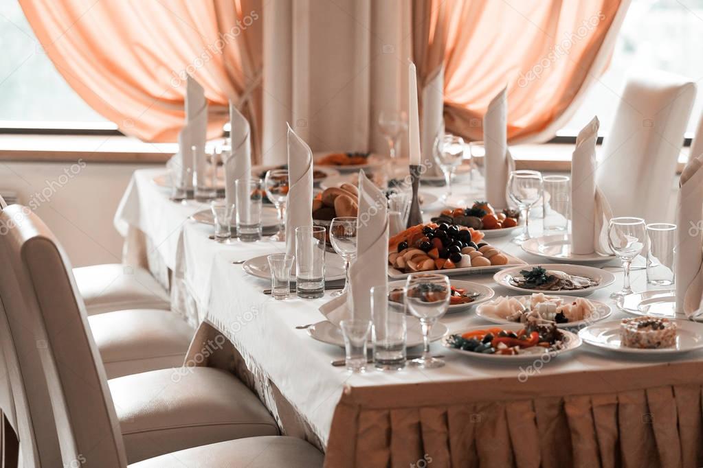 Wine glasses, napkins and fruit on the table for the banquet.