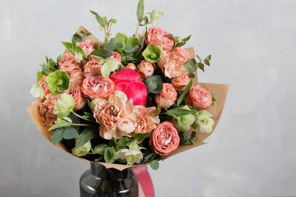 Buquê de flores diferentes em um arranjo misto contra a parede cinza no fundo. Espaço de cópia — Fotografia de Stock