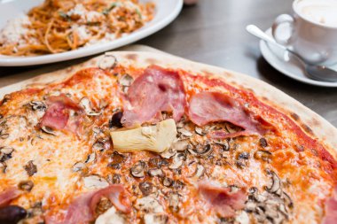 Enginar, jambon ve mantar pizza. yeme, işlemi pişirme aletleri