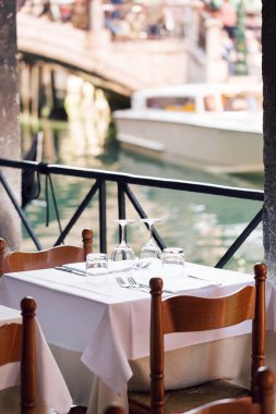 Restoran kanal Venedik. Canım akşam yemeği için Tablo ayarı. Boş gözlük kafede ayarlayın. İç parçası. peçeteler, tabak ve çatal bıçak takımı.