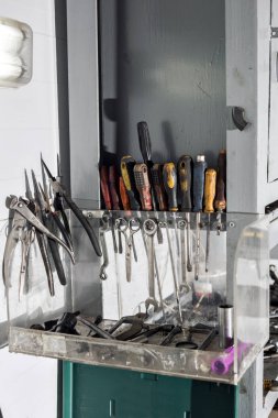 ürün yelpazesine kendiniz yapın bir dolabında bir duvara asılı çalışma araçları. kirli motor yağı